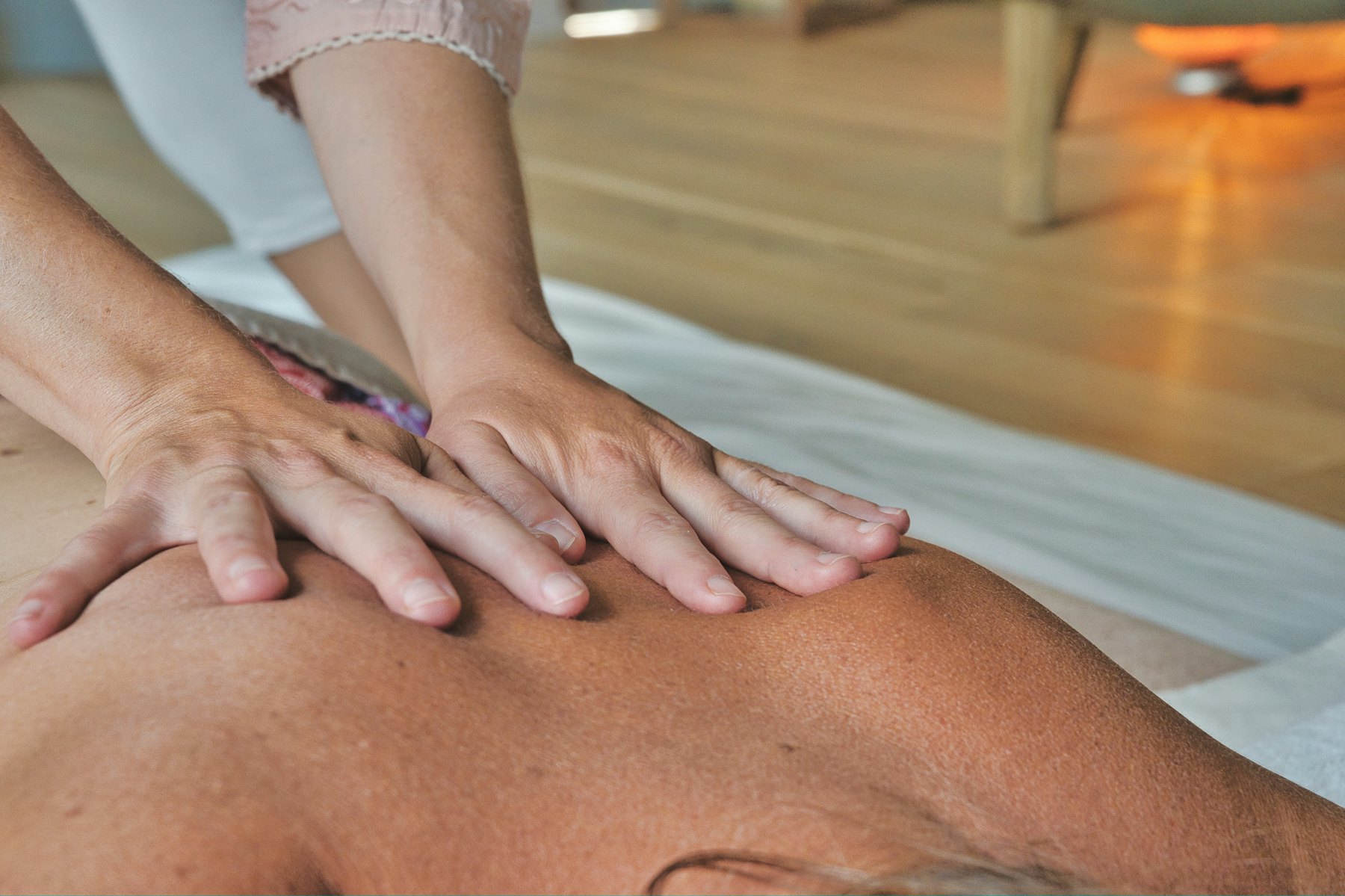 Fisioterapeuta con uniforme blanco trabajando la espalda de un paciente