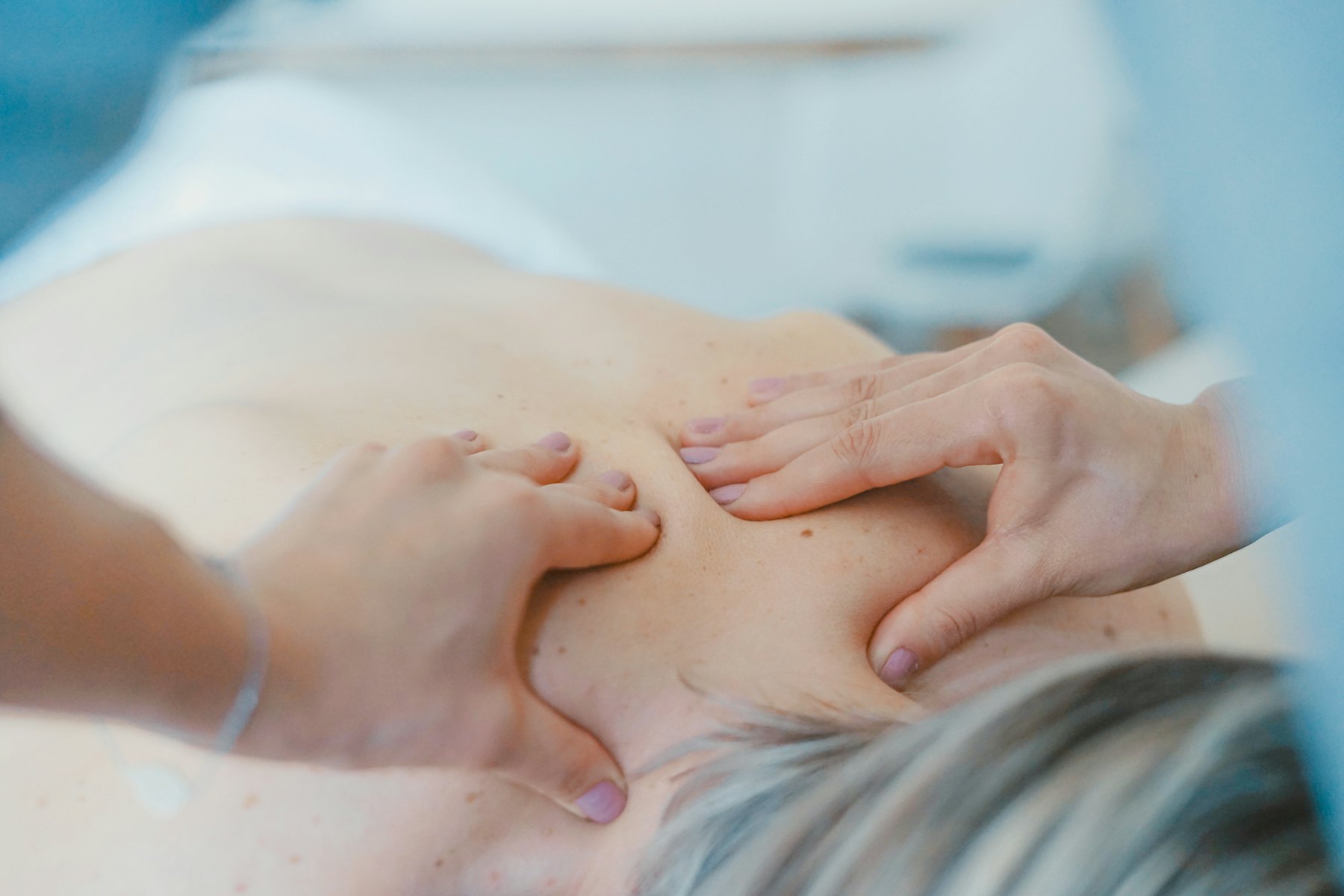 Manos de fisioterapeuta sobre la espalda